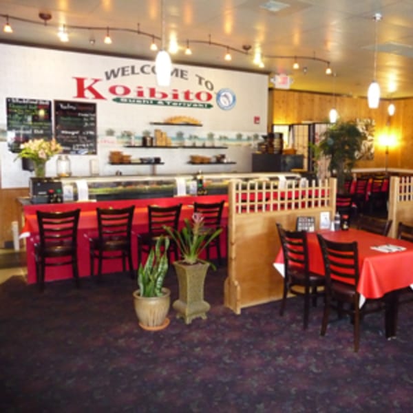 Interior of Koibito One Sushi & Teriyaki with a sushi bar, dining tables, and red accents.