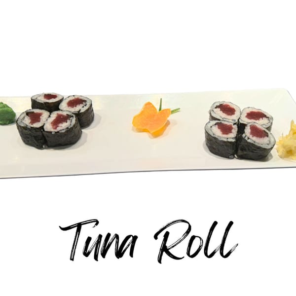 Two sets of tuna rolls with wasabi, ginger, and a carrot garnish on a white rectangular plate.