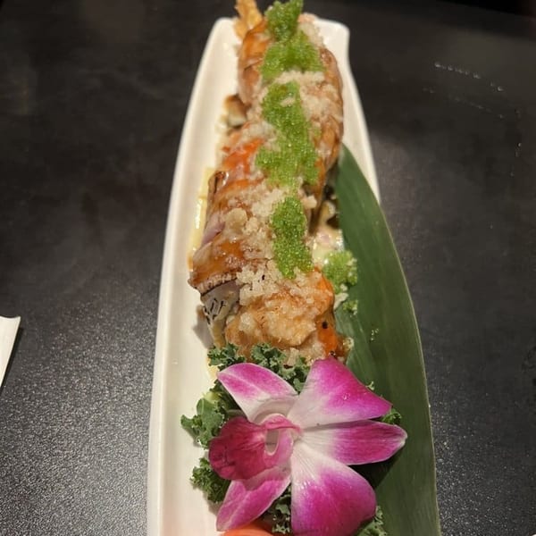 Koibito One Sushi & Teriyaki's fried shrimp sushi roll with green roe, served on a white dish.
