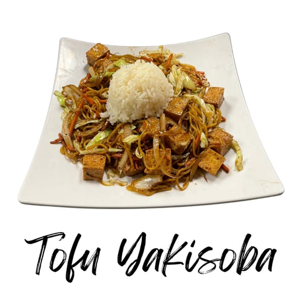 Tofu Yakisoba with noodles, vegetables, and a scoop of white rice on a white plate.