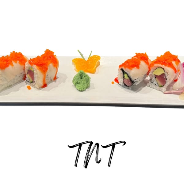 Four pieces of sushi with orange roe, wasabi, and a butterfly-shaped orange slice on a white plate.