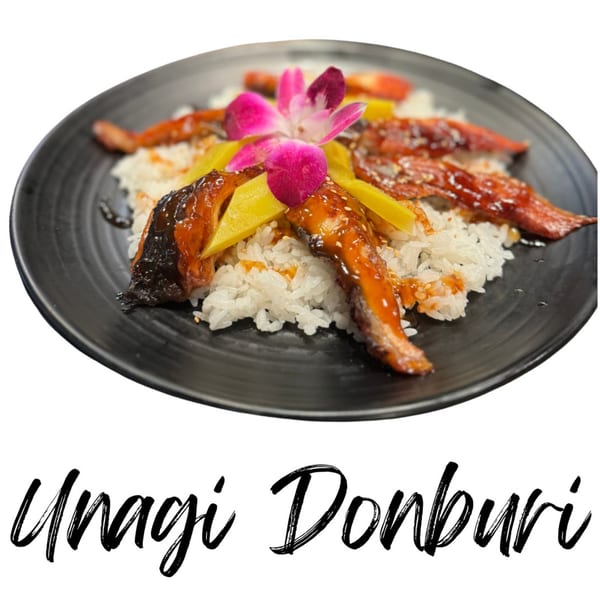 Unagi Donburi with grilled eel, yellow pickled daikon, and a pink orchid on white rice.