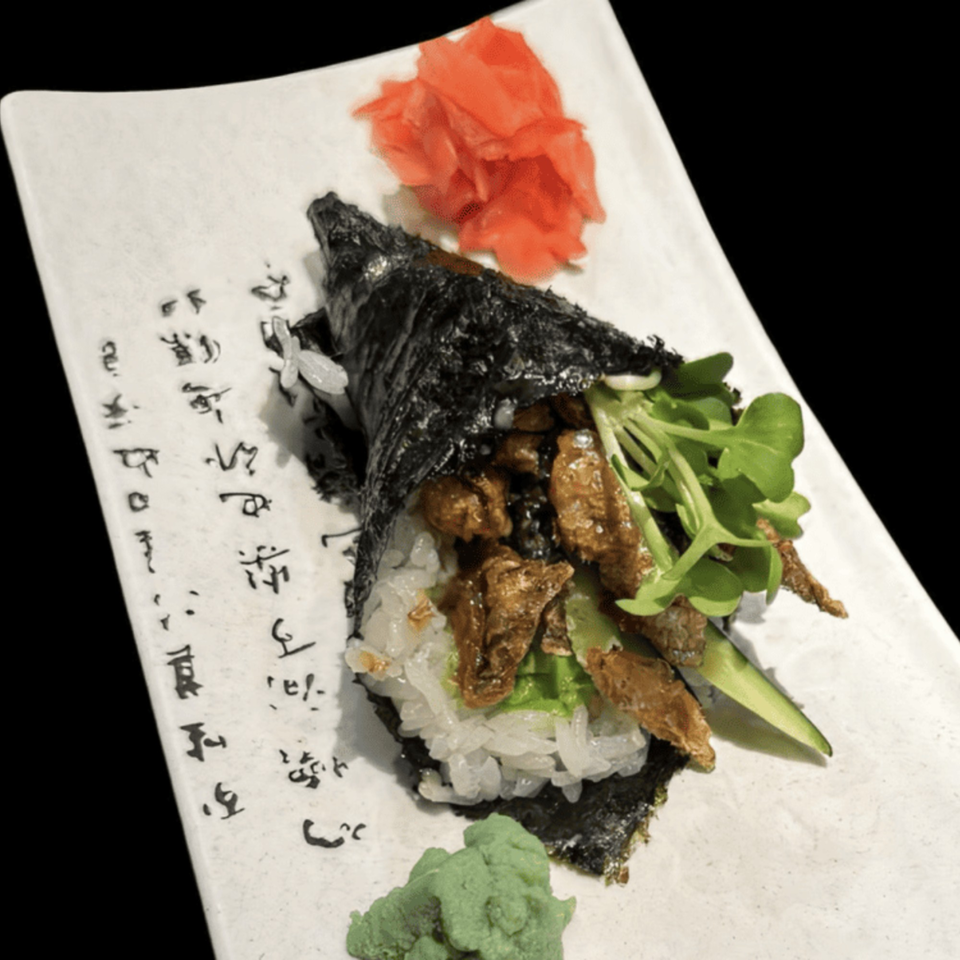 Koibito One Sushi & Teriyaki's hand roll with meat, greens, rice, pickled ginger, and wasabi.
