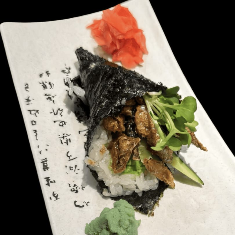 Koibito One Sushi & Teriyaki's hand roll with meat, greens, rice, pickled ginger, and wasabi.
