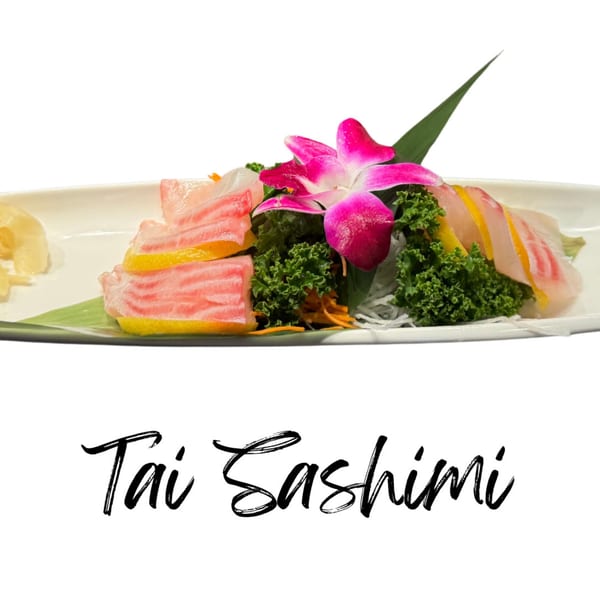 Tai Sashimi with lemon slices, garnished with a pink orchid, kale, and shredded daikon.