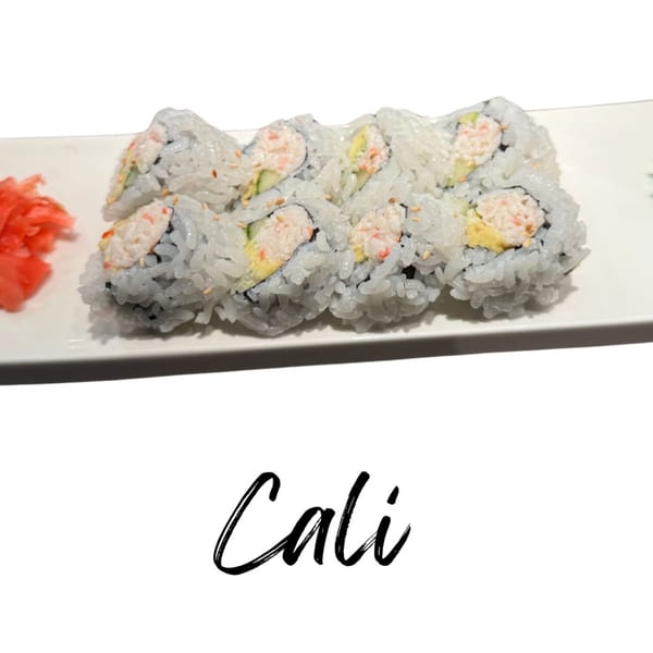 California sushi rolls with crab, avocado, and cucumber, served with pickled ginger on a white plate.