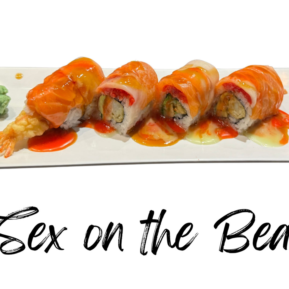Four sushi rolls with salmon, mango, and red sauce, alongside tempura shrimp and wasabi.