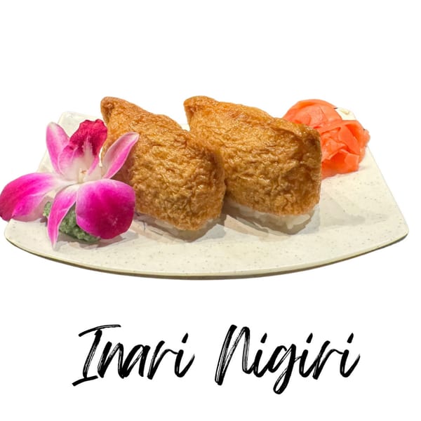 Two pieces of Inari Nigiri with pickled ginger and a pink orchid on a white plate.